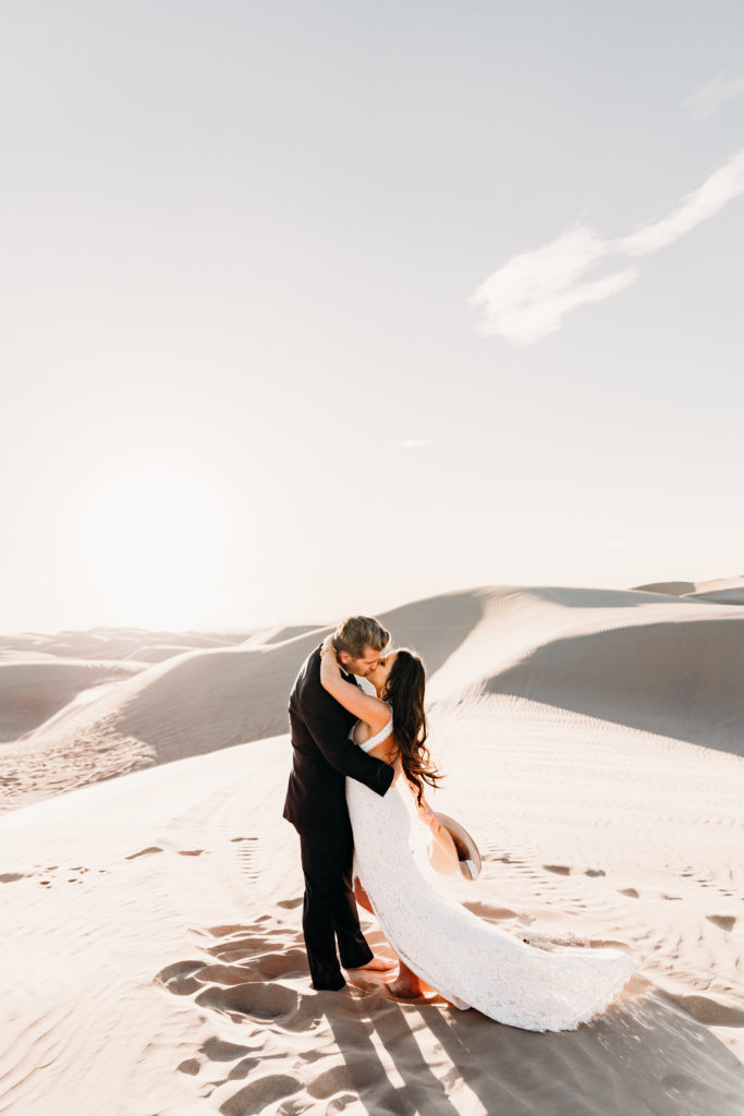 bride and groom kissing in sand dunes in Arizona