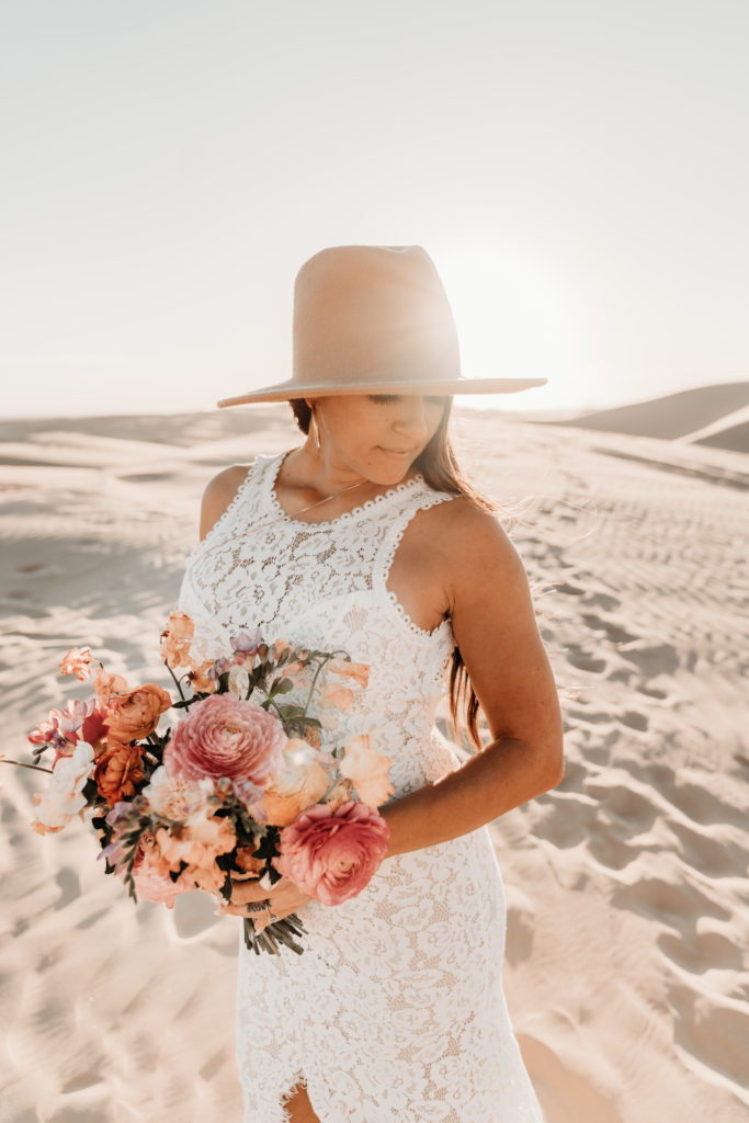 Bride holding bouquet and wearing hat