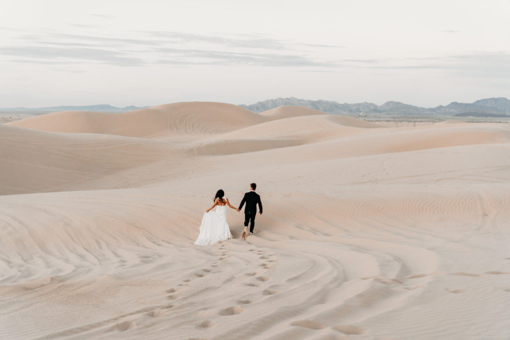 Sand Dunes elopement photos with bride and groom running in the sand