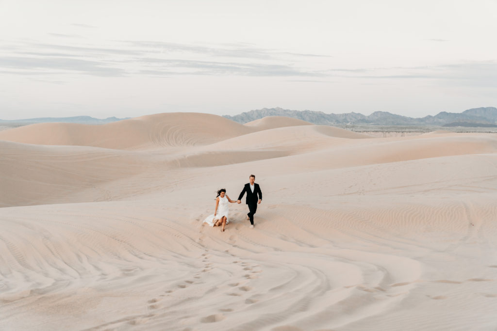 Wedding couple holding hands in Sand Dunes