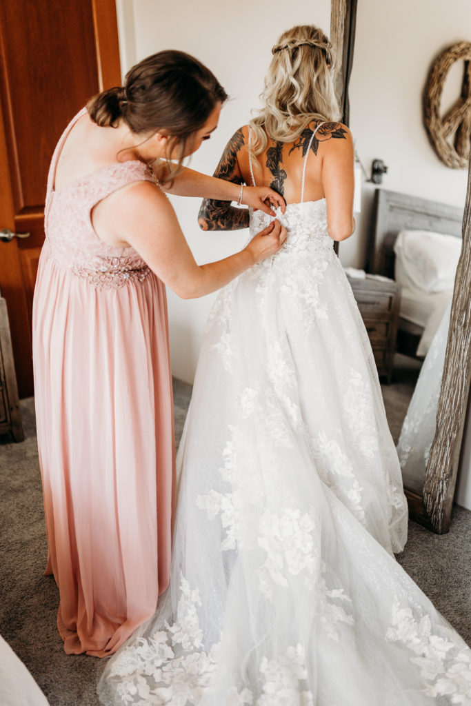 Bride putting on dress