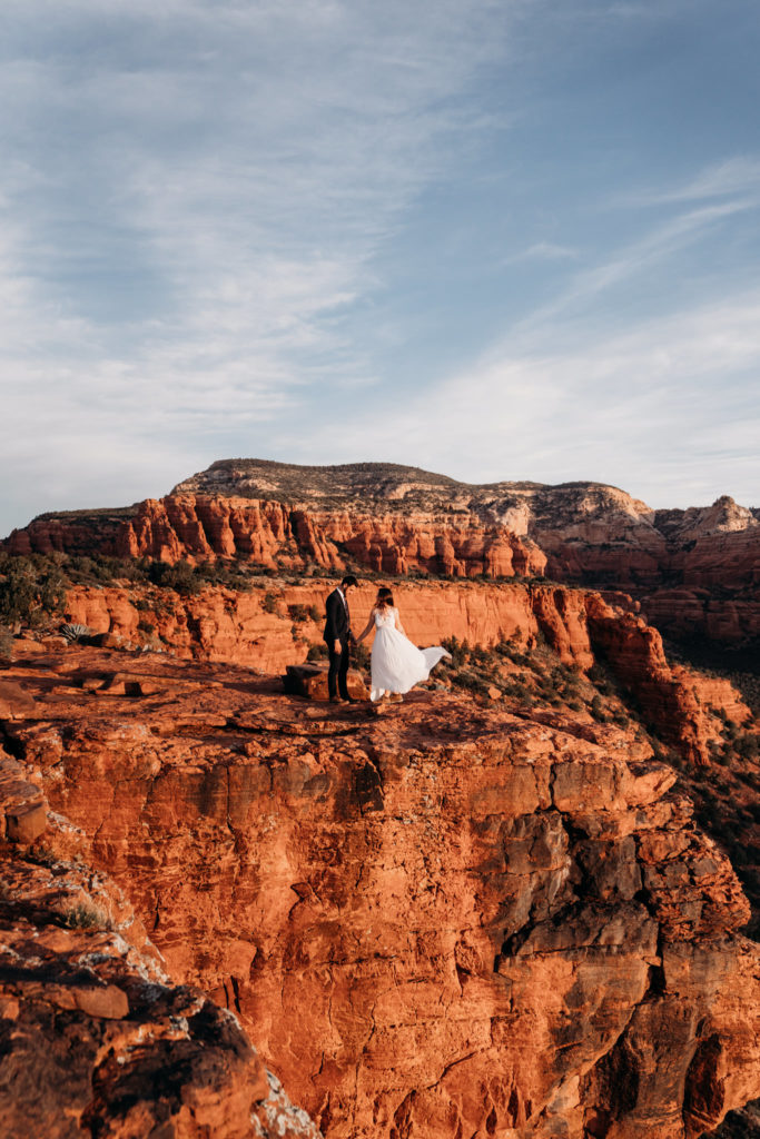 Bride and groom on Sedona red cliffs