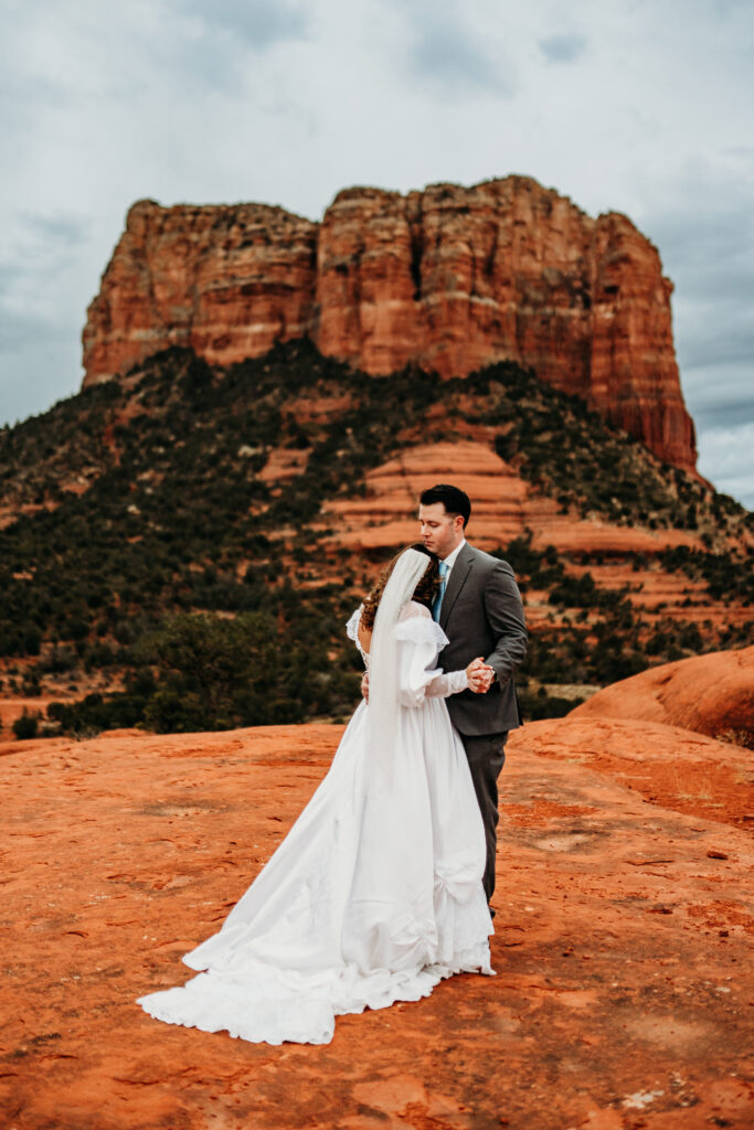 bride and groom having their first dance at bell rock in sedona arizona after eloping